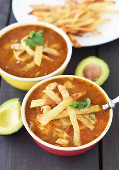 two bowls of chili and cheese soup with avocado