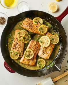 fish with lemons and herbs in a skillet