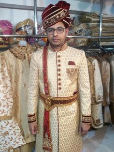 a man in a white and red outfit standing next to some clothes on display at a store