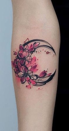 a woman's thigh with flowers on it and the moon in the middle of her leg