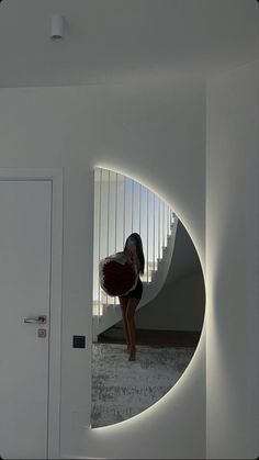 a woman standing in front of a mirror holding a red purse and looking at her reflection