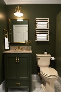 a bathroom with a toilet, sink and green cabinet in it's center area