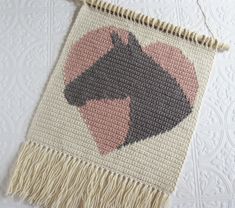 a crocheted rug with a horse head on it and fringes around the edges