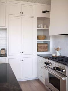 a kitchen with white cabinets and black counter tops is pictured in this image from the front view