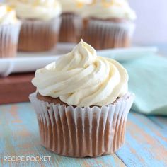 cupcakes with white frosting sitting on a table