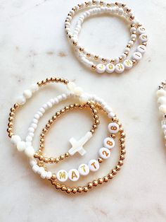 three beaded bracelets with the word faith written in white and gold beads on them