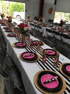 the tables are set with pink and black plates