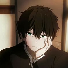 an anime character with green eyes and black hair looking at the camera, while holding his hand to his face