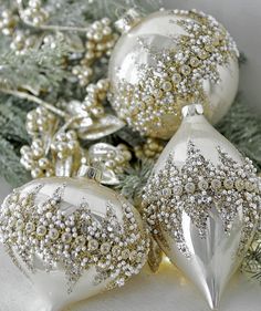 three white christmas ornaments sitting on top of a table