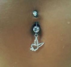 a woman's belly is adorned with two piercings and an earring made out of cubic zirconia