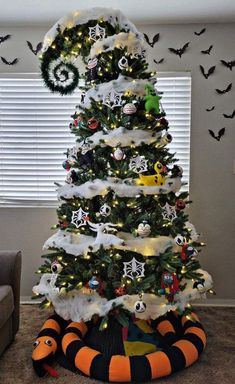 a decorated christmas tree in the corner of a living room with bats on the wall