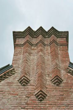 the corner of a brick building with an arrow pattern on it