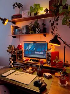 a desk with a computer and various plants on it