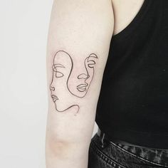 a woman's arm with a line drawing of two faces on the left side of her arm