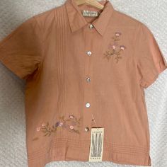 Lemon Grass Blouse Top Peach Color With Flowers Embroidery Womens Ladies Petite Small Ps New With Tags Nwt Summer Embroidered Collared Tops, Summer Collared Tops With Floral Embroidery, Spring Short Sleeve Blouse With Tonal Embroidery, Pink Floral Embroidery Summer Shirt, Pink Embroidered Button-up Blouse, Vintage Embroidered Summer Shirt, Spring Tops With Tonal Embroidery And Short Sleeves, Pink Embroidered Collared Top, Short Sleeve Tops With Tonal Embroidery For Spring