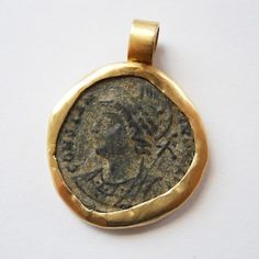 an ancient roman coin is displayed on a white surface with a gold ring around it