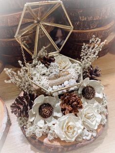 an arrangement of flowers and pine cones is displayed on a wood slice with a mirror in the background