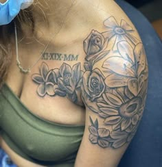 a woman's arm with flowers and the word maximum tattooed on it