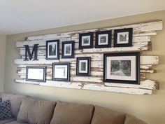 a living room filled with furniture and framed pictures on the wall above it's couch