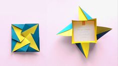 two origami stars on a pink wall next to a box with a card in it