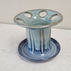 a blue vase sitting on top of a white table