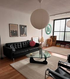 a living room filled with furniture and a glass top table in front of a large window