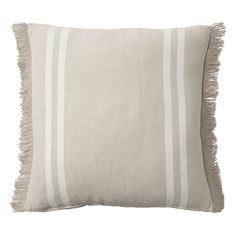 a white and grey striped pillow with fringes on the bottom, in front of a white background