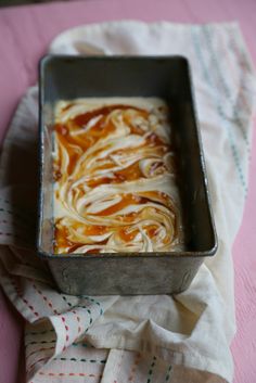 a metal pan filled with food on top of a pink table cloth and napkins