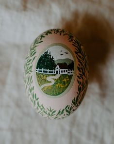 an ornament with a farm scene painted on it