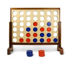 a giant four in a row board game with blue, red and orange pieces around it