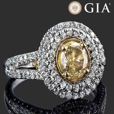 a fancy yellow diamond ring set in 18k white gold with diamonds around the band