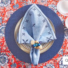 a blue and white place setting on a red table cloth