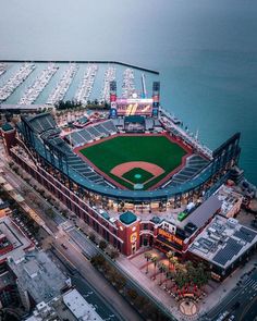 an aerial view of a baseball stadium with boats docked in the water and buildings around it