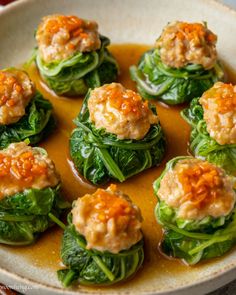 a white bowl filled with green vegetables covered in sauce