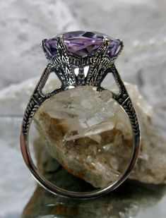 Natural Purple Amethyst Ring 100 Year Design#37 This is a brand new Edwardian reproduction filigree ring in antiqued solid sterling silver. The round full cut high-quality 5ct Natural Purple Amethyst gemstone is 12mm in diameter. The inside of the band is marked 925 for sterling. Notice the beautiful intricate crown-like design of the silver filigree setting and etched band. The original ring I bought in this exact design was from 1910. This is a rare and exact replica of that ring. A gift box i Art Deco Purple Amethyst Ring For Anniversary, Heirloom Purple Amethyst Ring With Intricate Design, Purple Amethyst Art Deco Ring For Anniversary, Heirloom Style Purple Amethyst Collectible Ring, Heirloom Purple Amethyst Collectible Ring, Victorian Amethyst Ring With Center Stone, Formal Amethyst Ring With Round Accent Stones, Formal Round Amethyst Ring With Accent Stones, Formal Amethyst Ring With Accent Stones