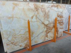 large marble slabs are lined up on orange stands in front of a storefront window