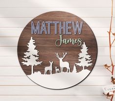 a wooden sign that says,'name james with deer and pine trees in the background