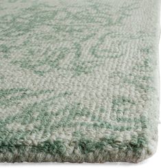 a green and white rug with wavy lines on the bottom, in front of a white background