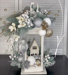 a white christmas wreath with silver and gold ornaments