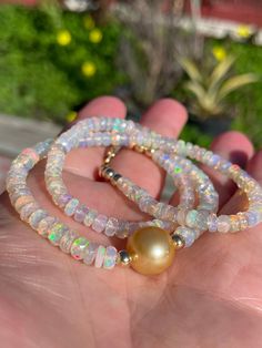 "Large (4.5-5mm) and beautiful faceted Ethiopian opal rondelles frame a flawless 11mm deep golden South Sea pearl.  The snow-white opals make a lovely contrast to the pearl, with their subtle multi-colored fire, and the South Sea pearl is a rich shade of gold. Necklace measures 16\" - 19\" in length and can be worn as a choker and layered with other pieces; it comes accented with 14K yellow gold-filled beads around the pearl and at the lobster clasp, with an additional 3\" gold-filled extender chain at the clasp.  If you prefer a different length, please convo me or let me know in the check-out comments. Thanks for checking out my shop!" Elegant Ethiopian Opal Gemstone Beads Jewelry, Pearl Rondelle Jewelry With Faceted Beads, Rondelle Pearl Jewelry With Faceted Beads, Elegant Opal Beaded Necklace, Elegant Beaded Opal Necklace, Elegant White Pink Opal Jewelry, Elegant Opal Jewelry With Gemstone Beads, Ethiopian Opal Rondelle Jewelry Gift, Faceted Round Opal Jewelry