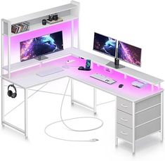 a computer desk with two monitors and a keyboard on it, all lit up in pink