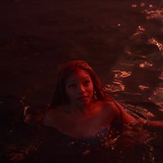 a woman is swimming in the water at night