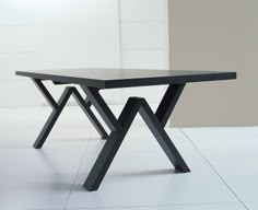 a black table sitting on top of a white tile floor next to a wall and window