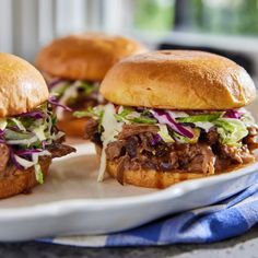 three pulled pork sandwiches on a white plate