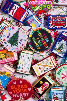 many different types of embroidered badges and magnets on a white surface with christmas decorations