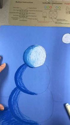 someone is drawing a snowman with blue crayons on the paper and pencils