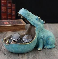 a ceramic figurine of an elephant with glasses in it's mouth