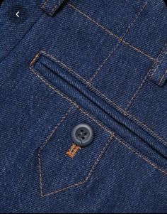 the back pocket of a pair of jeans with buttons on each side and an orange stripe down the middle