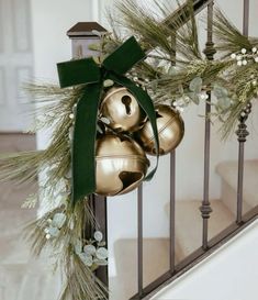 christmas decorations on the banister with bells and greenery