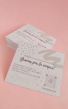 two white business cards sitting next to each other on a pink surface with the numbers 20 and twenty